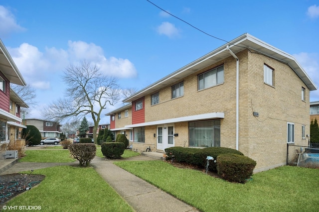 exterior space featuring fence, a lawn, and brick siding