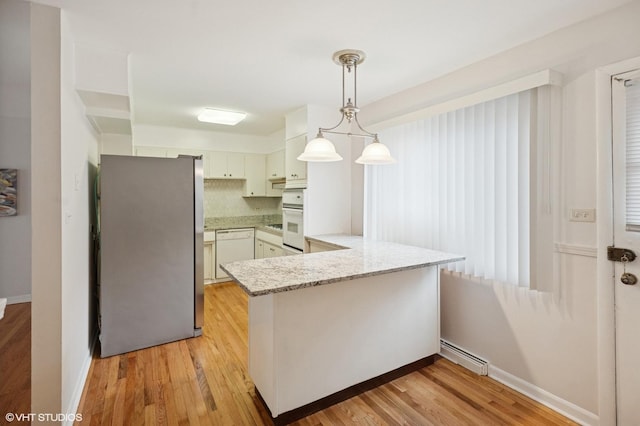 kitchen featuring a peninsula, white dishwasher, freestanding refrigerator, and light wood-type flooring