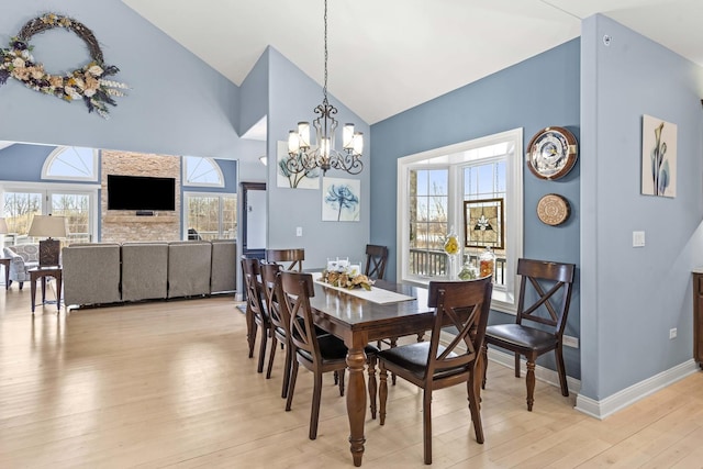 dining room featuring lofted ceiling, an inviting chandelier, and light wood-type flooring