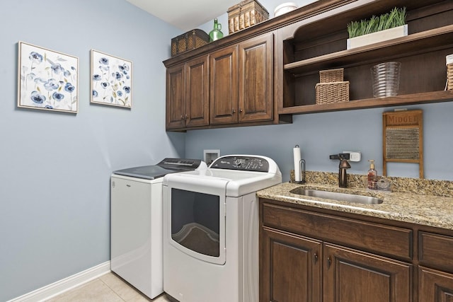 laundry area with cabinets, sink, washer and dryer, and light tile patterned floors