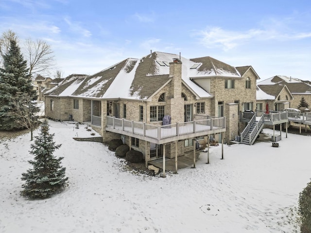 snow covered property with a wooden deck