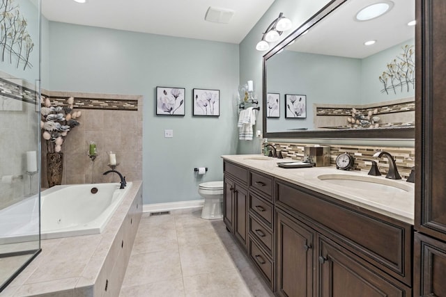 bathroom featuring vanity, tiled tub, tile patterned flooring, and toilet