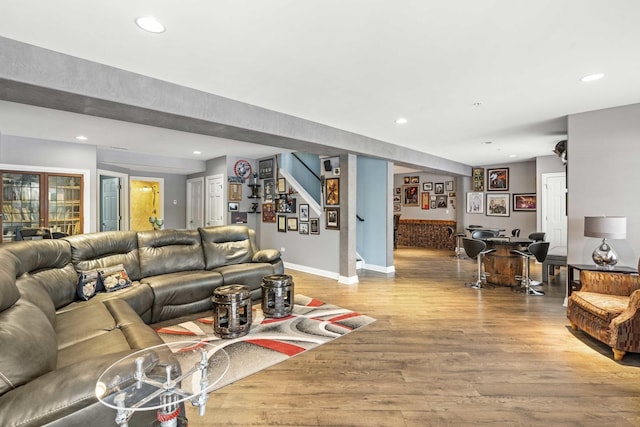 living room with bar and light wood-type flooring