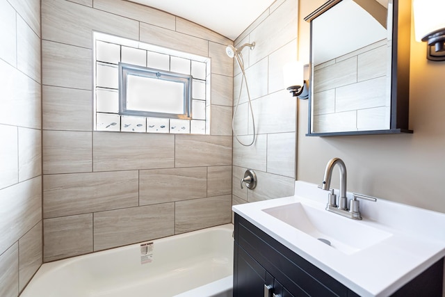 bathroom with tiled shower / bath combo and vanity