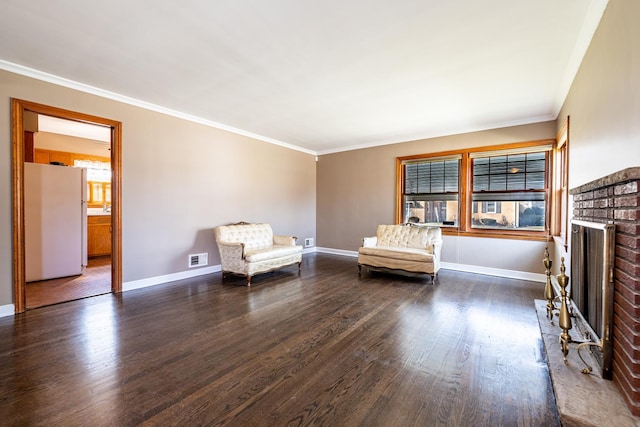 sitting room with dark hardwood / wood-style flooring, ornamental molding, and a fireplace