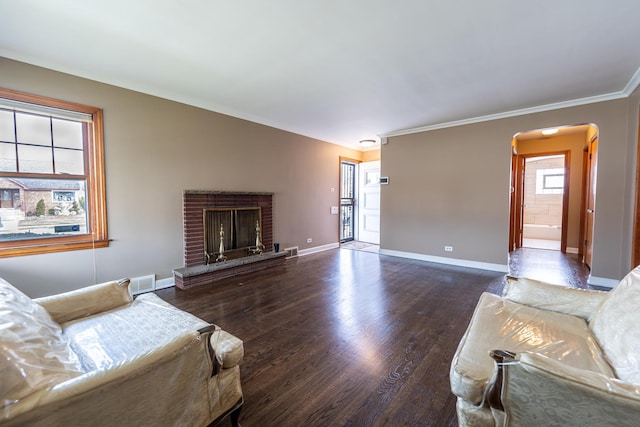 living room featuring crown molding, dark hardwood / wood-style floors, and a brick fireplace