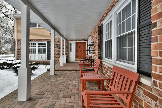 snow covered patio featuring a porch