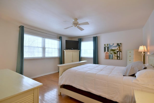 bedroom featuring light wood-style floors, ceiling fan, and baseboards