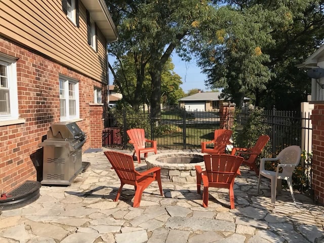 view of patio / terrace with an outdoor fire pit, a grill, and fence