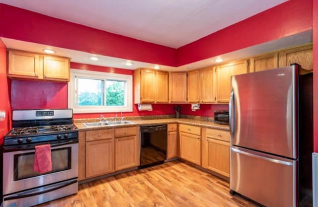 kitchen with sink, light wood-type flooring, and appliances with stainless steel finishes