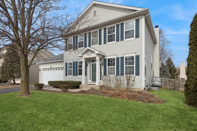 colonial inspired home with a garage and a front yard