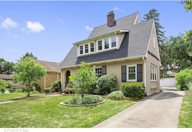 view of front of house featuring a garage, an outdoor structure, and a front yard