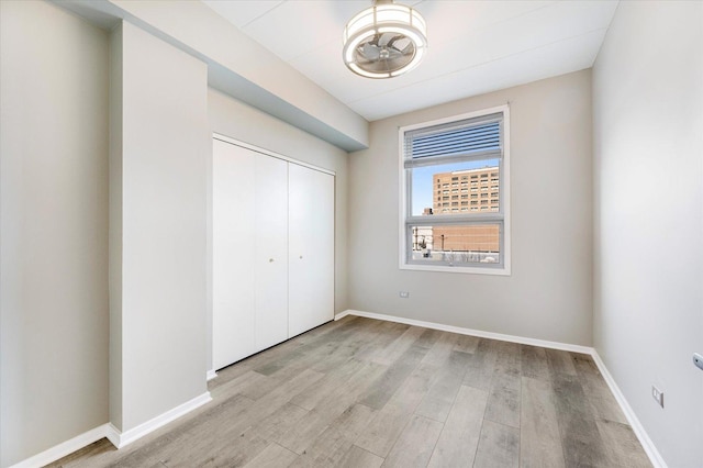 unfurnished bedroom with light wood-type flooring and a closet