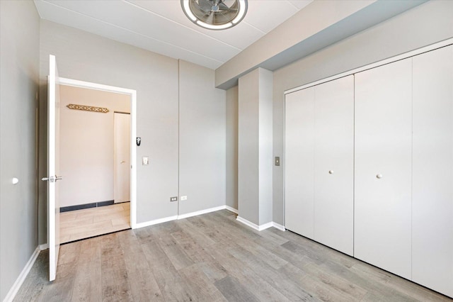 unfurnished bedroom featuring light hardwood / wood-style floors and a closet