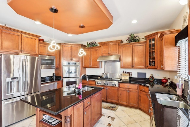 kitchen featuring pendant lighting, appliances with stainless steel finishes, sink, and a center island with sink