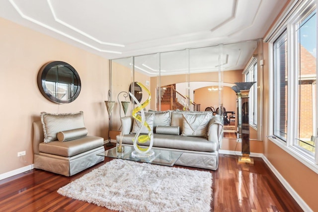 living room with plenty of natural light, dark wood-type flooring, and a chandelier