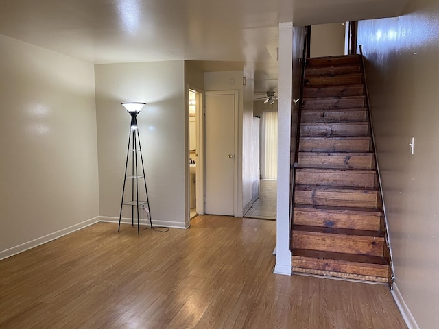 staircase featuring ceiling fan and hardwood / wood-style floors