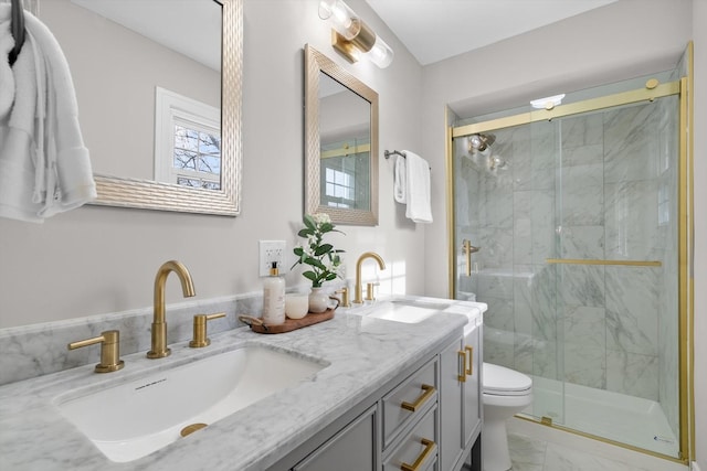 bathroom featuring toilet, vanity, and a shower with shower door