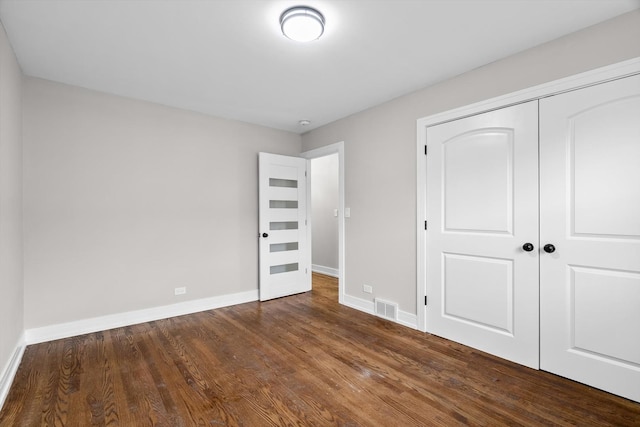 unfurnished bedroom featuring hardwood / wood-style floors and a closet