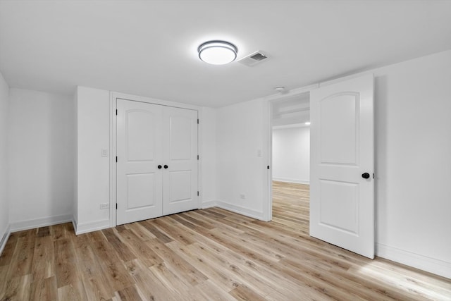 unfurnished bedroom with a closet and light wood-type flooring