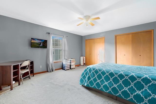 carpeted bedroom featuring multiple closets and ceiling fan