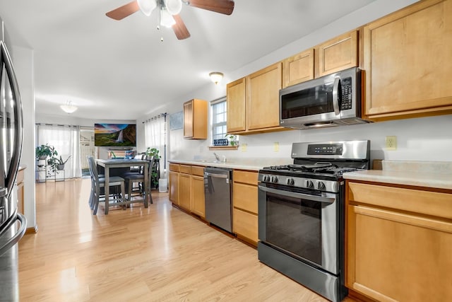 kitchen featuring sink, stainless steel appliances, light hardwood / wood-style floors, and light brown cabinets