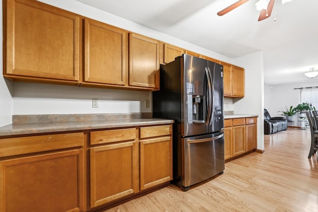 kitchen featuring stainless steel refrigerator with ice dispenser, ceiling fan, and light wood-type flooring