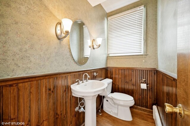 bathroom featuring baseboard heating, sink, toilet, and hardwood / wood-style floors