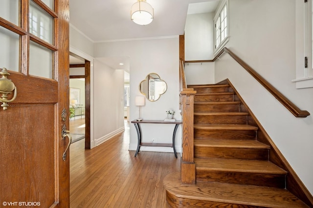 foyer entrance featuring ornamental molding and wood-type flooring