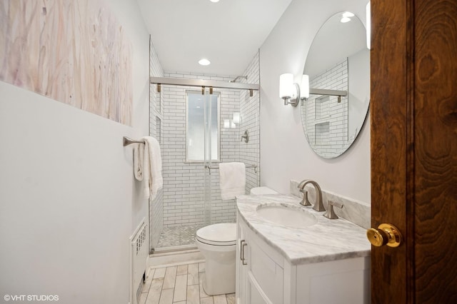 bathroom with vanity, a shower with shower door, and toilet