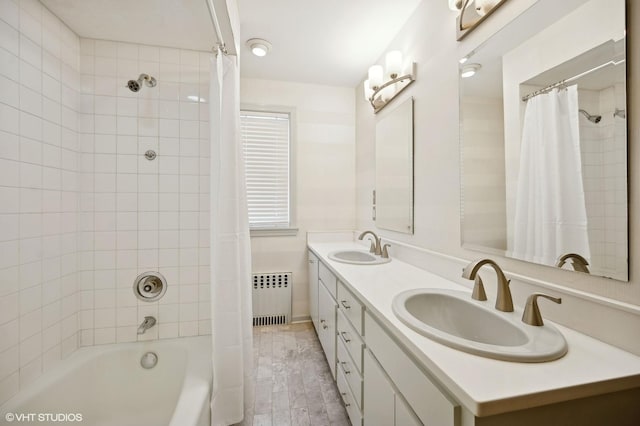 bathroom with radiator heating unit, shower / bath combo with shower curtain, and vanity