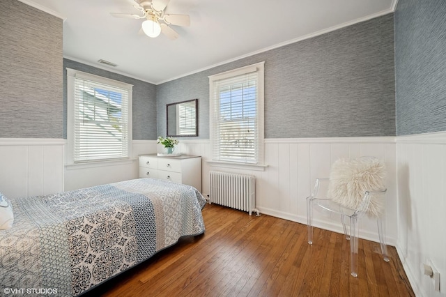 bedroom featuring crown molding, ceiling fan, radiator, and hardwood / wood-style floors