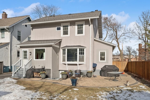 snow covered house featuring a patio area