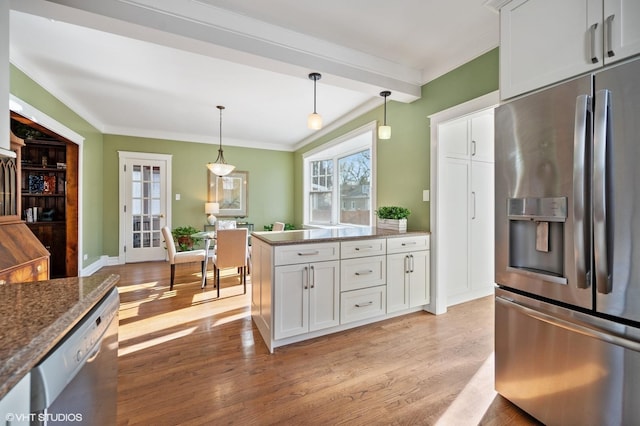 kitchen featuring white cabinetry, pendant lighting, stainless steel appliances, and light hardwood / wood-style floors