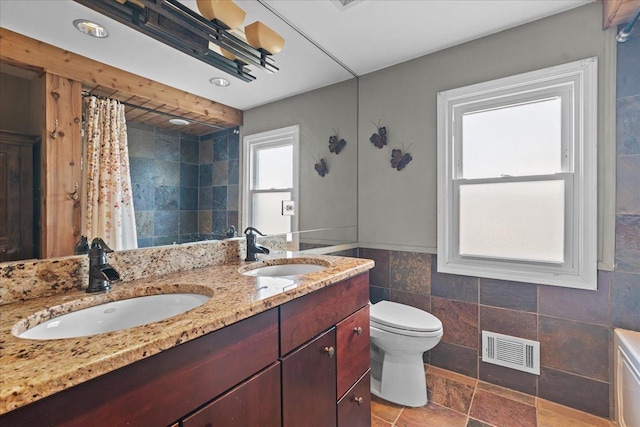 bathroom with tile walls, vanity, a shower with curtain, and toilet