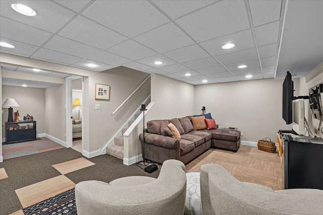 carpeted living room featuring a paneled ceiling