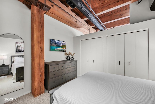 bedroom with light colored carpet and two closets