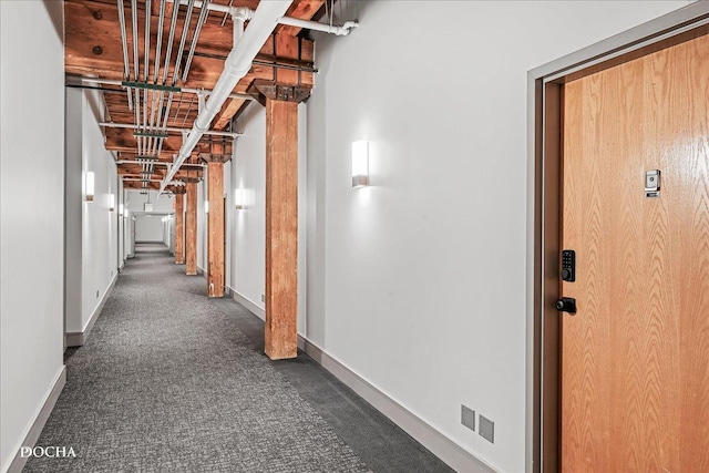 hallway with dark colored carpet