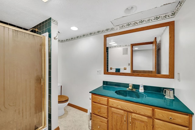 bathroom with vanity, toilet, a shower with door, and a textured ceiling