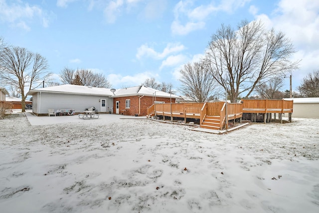 snow covered property featuring a wooden deck