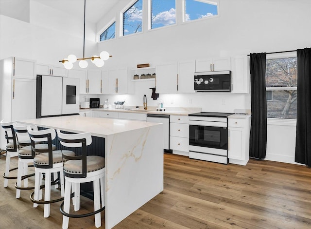 kitchen with white fridge, dishwashing machine, pendant lighting, stainless steel electric stove, and white cabinets