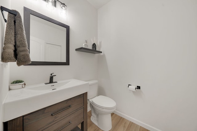 bathroom featuring vanity, wood-type flooring, and toilet