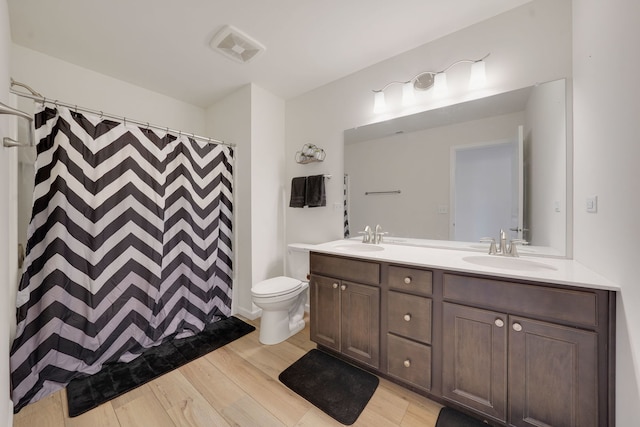 bathroom with vanity, hardwood / wood-style flooring, curtained shower, and toilet