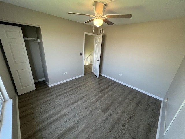 unfurnished bedroom featuring dark hardwood / wood-style floors, ceiling fan, and a closet