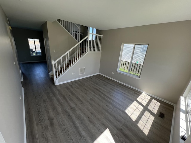 unfurnished living room with a wealth of natural light and dark hardwood / wood-style flooring