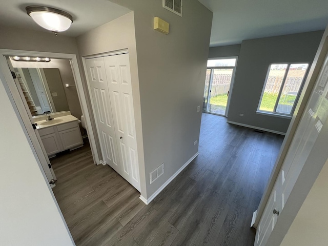 corridor featuring dark wood-type flooring and sink