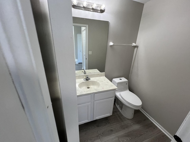 bathroom with hardwood / wood-style flooring, vanity, and toilet