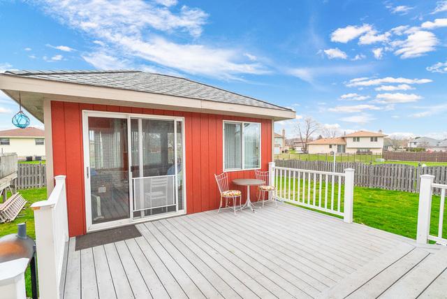 wooden terrace with a fenced backyard, a residential view, and a lawn