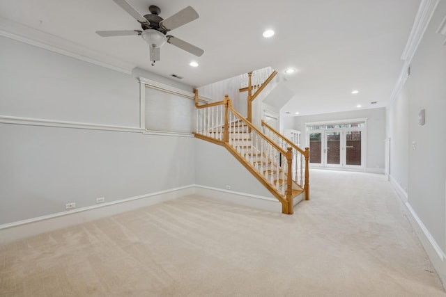 interior space with ornamental molding, light carpet, and ceiling fan