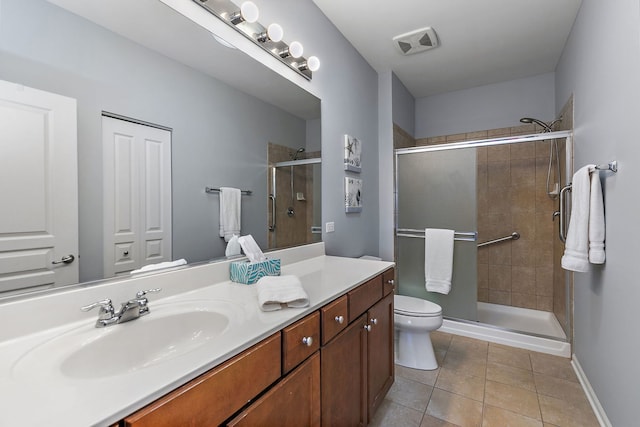 bathroom with tile patterned floors, toilet, an enclosed shower, and vanity